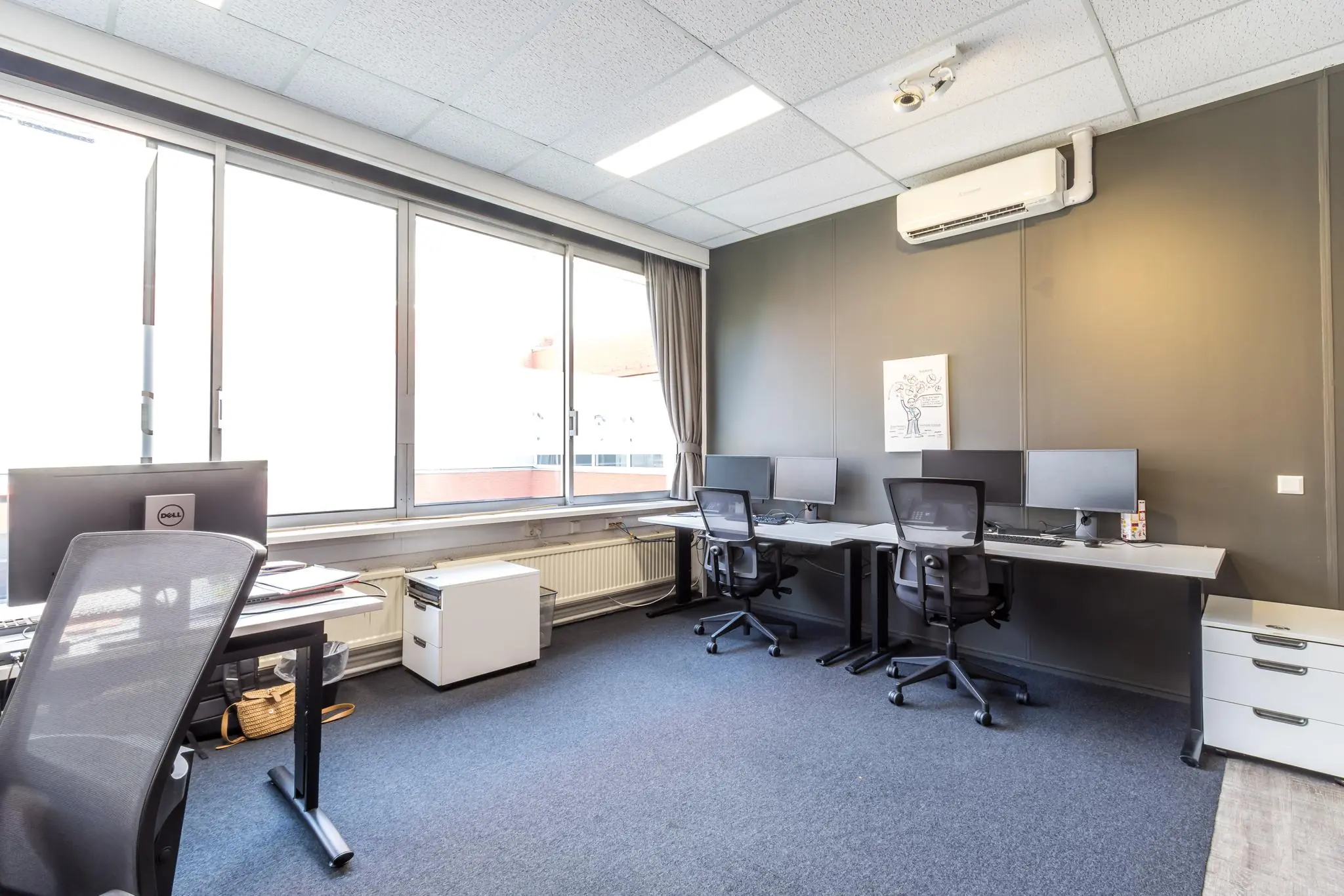 Moderne kantoorruimte aan de Jan van Eycklaan met meerdere werkplekken, grote ramen en strakke inrichting.